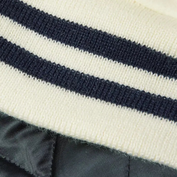 Close-up of a white varsity jacket with navy and white stripes