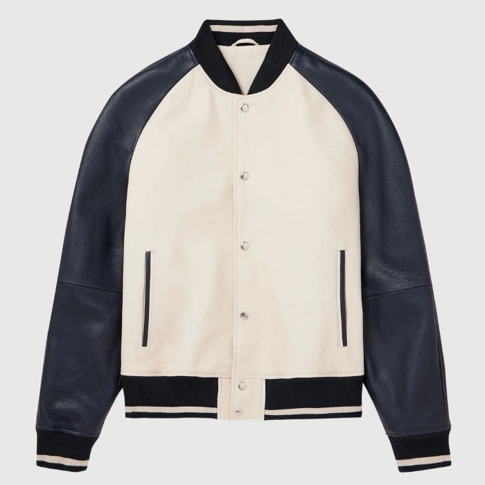 Flat lay of beige varsity jacket with black leather sleeves and ribbed trims.