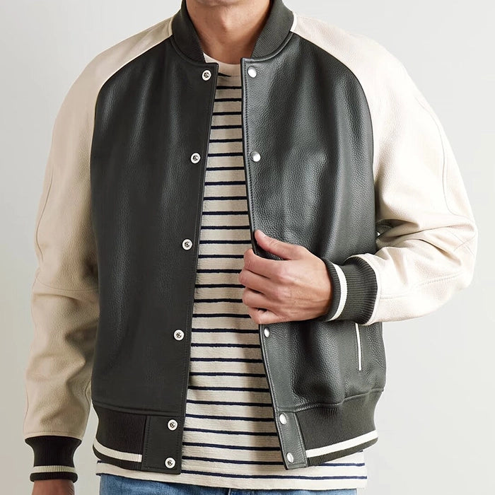 Front view of black and cream leather varsity jacket styled with a striped shirt underneath.