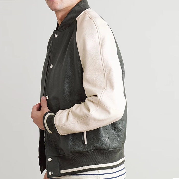 Side view of black leather varsity jacket with beige sleeves worn by model.