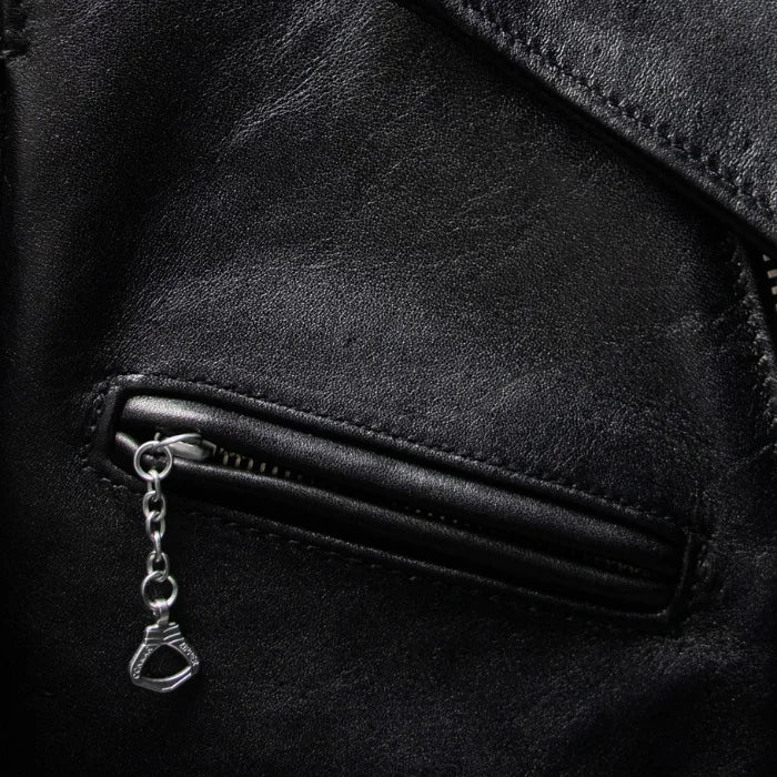 Close-up of a black moto leather jacket zipper with a silver chain tag.