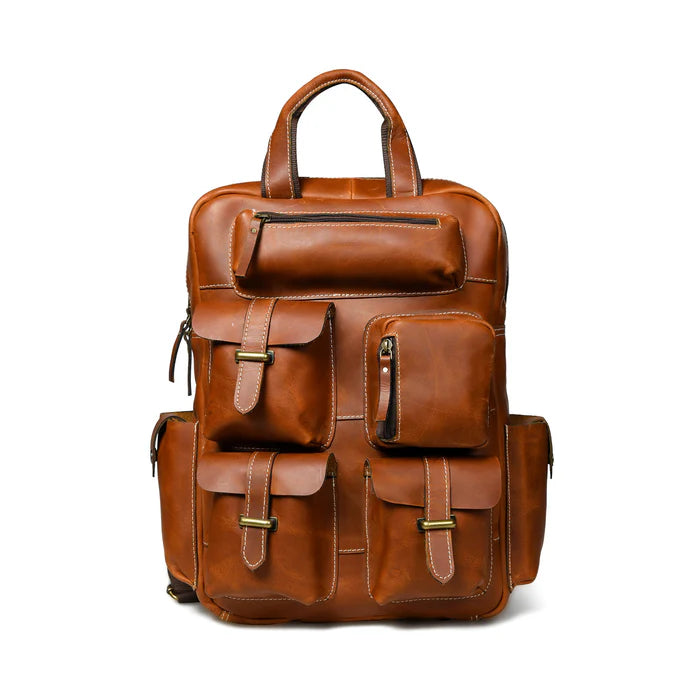 A mahogany brown leather backpack with multiple pockets and a vintage-inspired design.