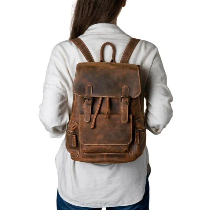 Person wearing a brown leather backpack on a white background
